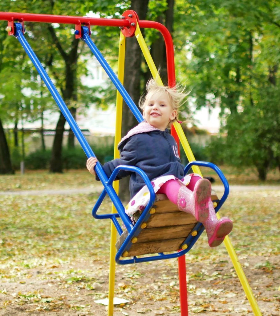 The child is riding on a swing